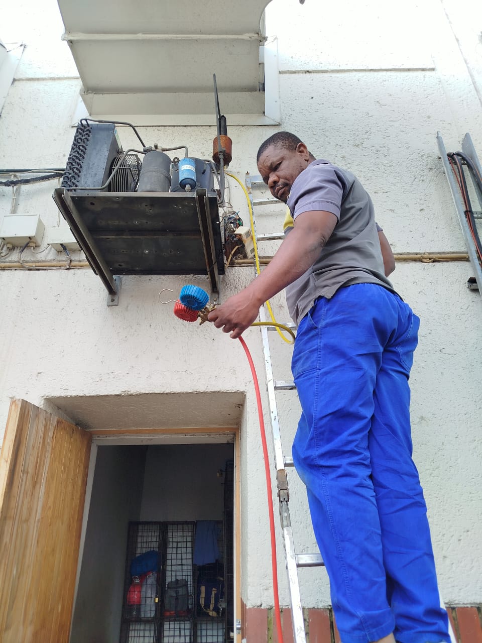 PrideAir aircon technician working on a split unit installation in Sandton